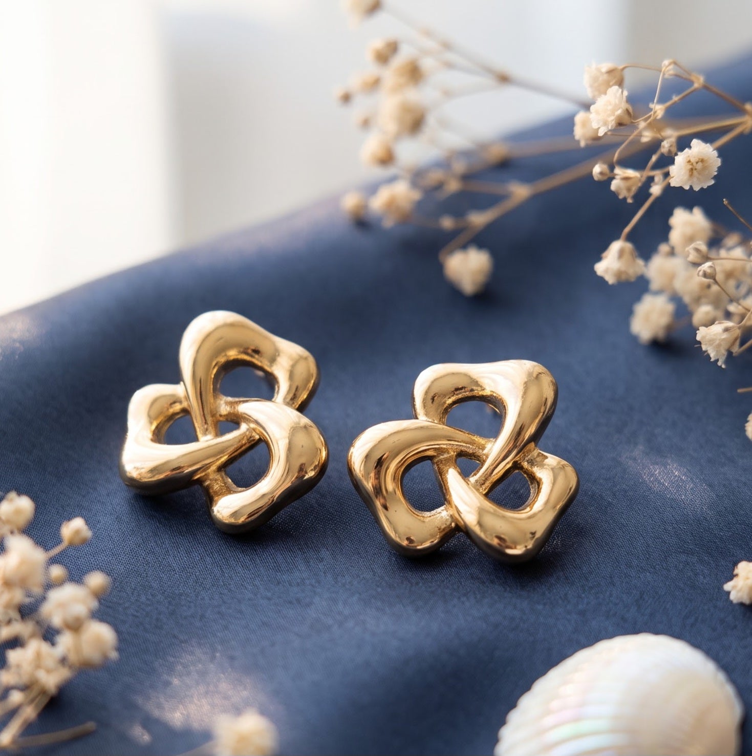 Gold stud earring with abstract knot design